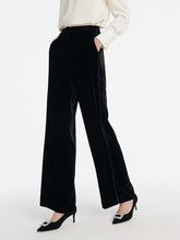 A lady wears velvet pants in black.